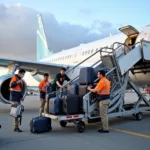 Airport ground staff loading luggage onto an aircraft