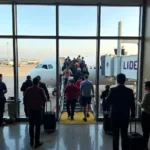 Passengers boarding a plane at a domestic airport gate